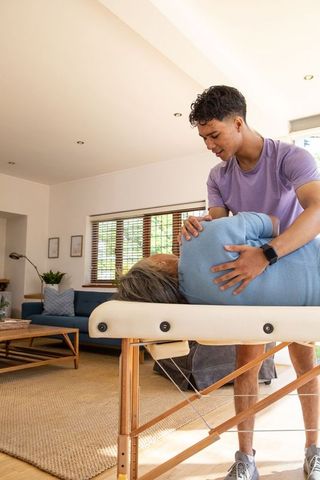 Manual Therapy Session with Asian Therapist and Senior Client at Home