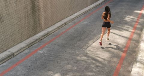 Woman Jogging in Urban Setting on Sunlit Street - Download Free Stock Images Pikwizard.com