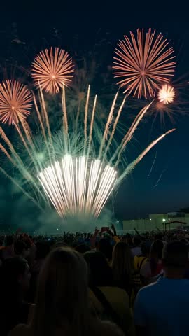 Crowd Filming Vertical Fireworks Spectacle with Golden Fan Bursts and Red Chrysanthemum Shells