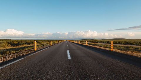 Endless Straight Highway Stretching Toward Horizon on Rural Plain at Golden Hour