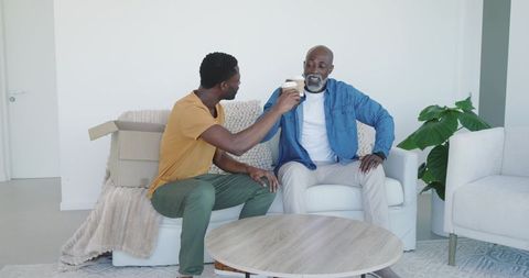 Father and Son Sharing Coffee in Comfortable Living Room