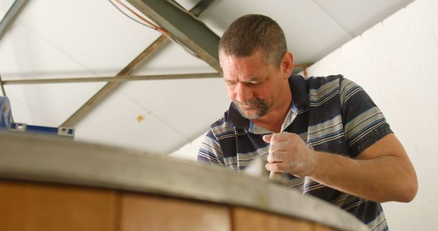 Middle-aged man working in metal workshop - Download Free Stock Images Pikwizard.com