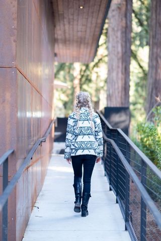 Woman Walking in Forest Surrounded by Cedar Trees