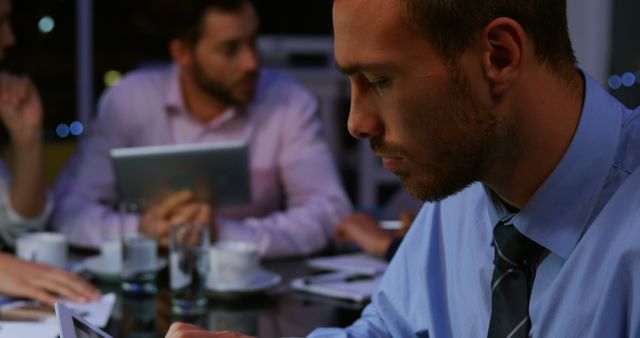 Focused Businessman in Late-Night Team Meeting - Download Free Stock Images Pikwizard.com