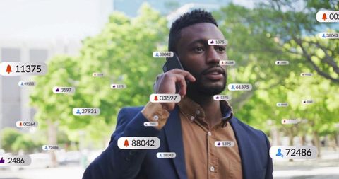 Professional man talking on smartphone with floating social media notification badges in city plaza