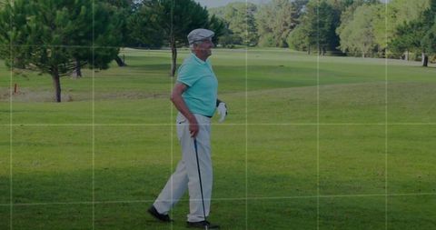 Senior golfer walking across lush golf course on sunny day
