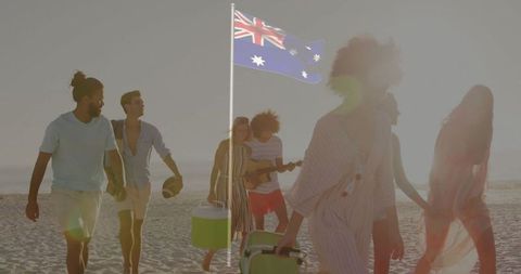 Group of Friends Walking Along Beach at Sunset Near Australian Flag