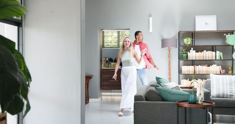 Couple tidying up after house party in living room