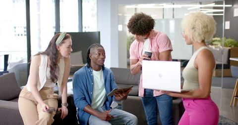 Diverse Team Collaborates on Office Project Using Technology