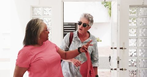 Senior Lesbian Couple Entering Hotel Enjoying Vacation