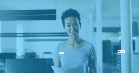 Professional Worker in Open-Plan Office Holding Documents