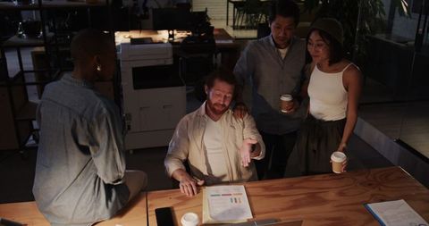 Diverse team collaborating on project late at night