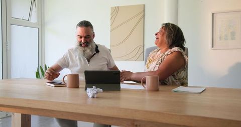Cheerful Senior Couple Discussing Digital Content at Home