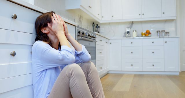 Woman Sitting on Kitchen Floor Appears Stressed: Mental Health and Lifestyle Concepts - Download Free Stock Images Pikwizard.com