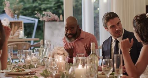 Guests engaged in conversation at outdoor wedding reception dinner