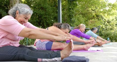Diverse group of women practicing yoga and stretching outdoors