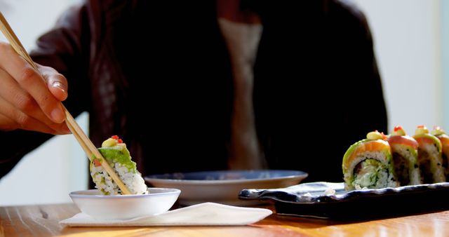 Person Eating Sushi with Chopsticks in Casual Restaurant - Download Free Stock Images Pikwizard.com