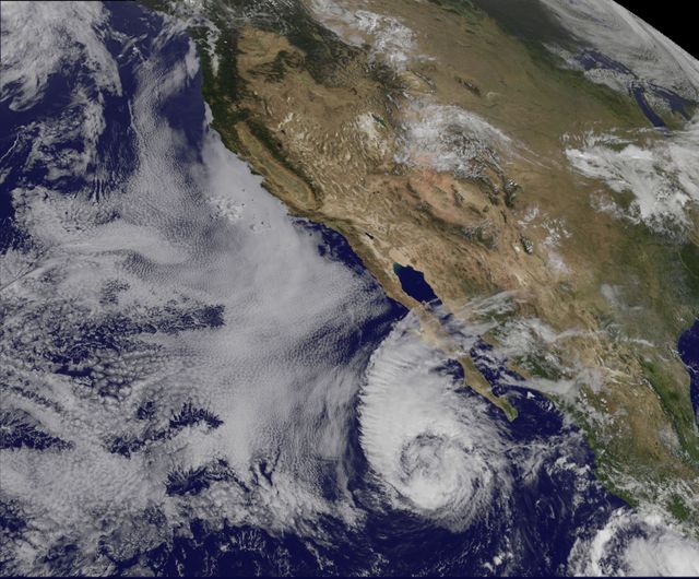 Satellite image showing Tropical Storm Miriam near Baja California captured by NOAA's GOES-15 satellite on September 26, 2012. Image displays swirling cloud formations and stratocumulus clouds surrounding the storm. Due to high southwesterly wind shear, storm begins to weaken with reducing wind speeds. Can be used in meteorological studies, weather forecasting reports, climate change research, or educational materials about natural disasters.