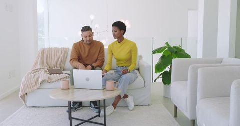 Couple Collaborating on Laptop Together in Modern Living Room