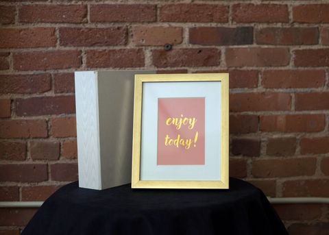 Chic framed inspirational quote on table with exposed brick background