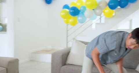 Asian man tidying up house after celebration