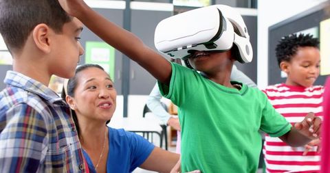 Children engaging with virtual reality in classroom learning environment