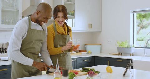 Diverse Couple Joyfully Preparing Meal Together in Modern Kitchen