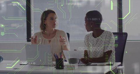 Two women collaborating with technology overlay in modern office