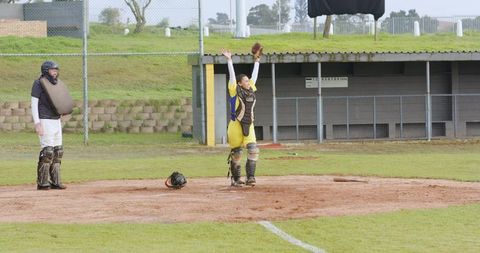 Senior umpire and catcher celebrating play on baseball field