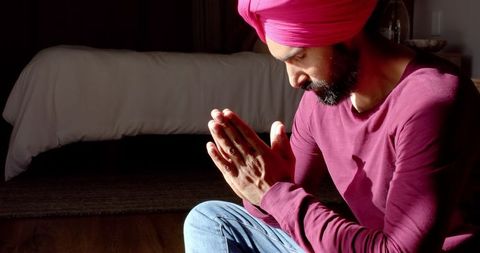 Man in turban meditating in quiet bedroom setting