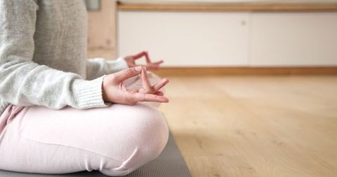 Woman Meditating Cross-Legged on Carpet in Calm Minimalist Room