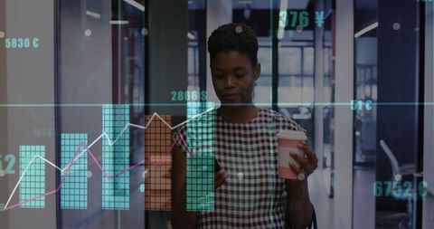 Businesswoman analyzing financial data in modern office corridor
