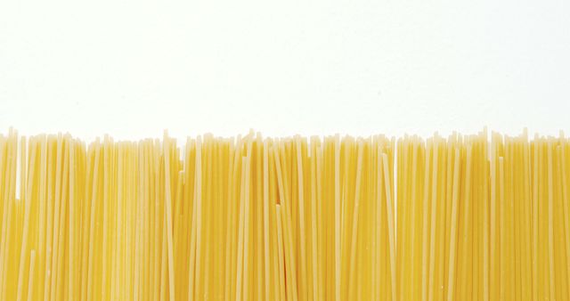 Close-up of raw spaghetti arranged on white background