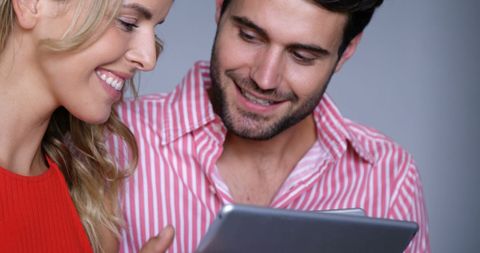 Smiling Couple Engaging Together with Digital Tablet