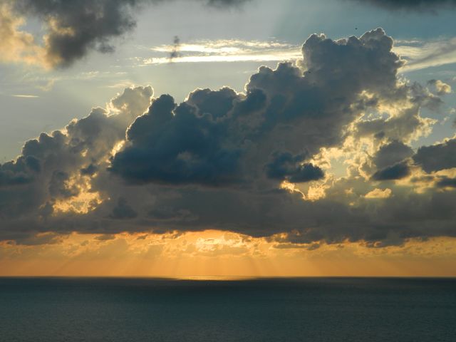 Dramatic Sunset Over Ocean with Sunlight Breaking Through Clouds - Download Free Stock Photos Pikwizard.com