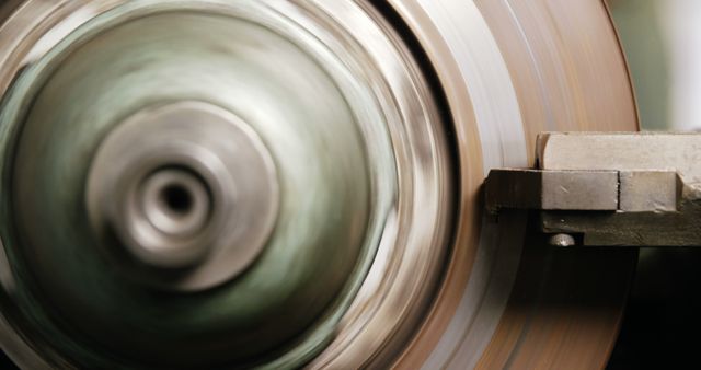 This image captures a close-up view of a machine lathe in action as it spins a metal part. Ideal for use in articles, brochures, or websites related to engineering, manufacturing, precision mechanics, and industrial technology.