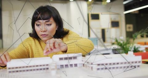 Focused Architect Designing Innovative Scale Model in Modern Studio