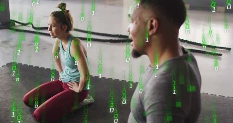 Trainer Coaching Woman Resting After Intense Battle Rope Workout in Modern Gym Studio