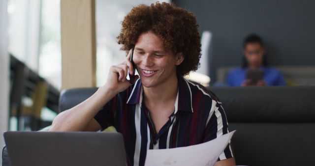 Young Man Smiling Working Remotely on Laptop and Phone - Download Free Stock Images Pikwizard.com