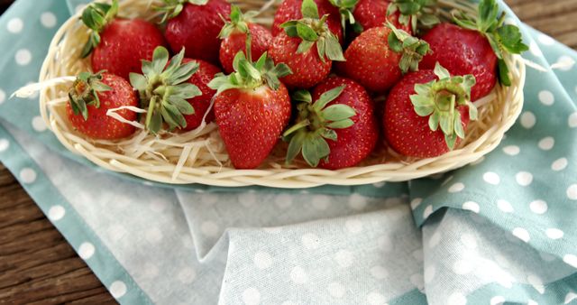 A basket of fresh, ripe strawberries sits atop a polka-dotted cloth, with copy space. Vibrant red berries offer a visual treat, suggesting a theme of healthy eating or summer harvest.