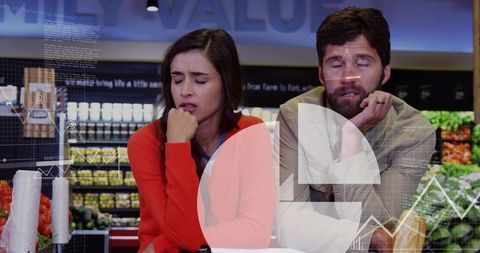 Exhausted couple leaning on grocery counter with futuristic data overlay and fresh produce
