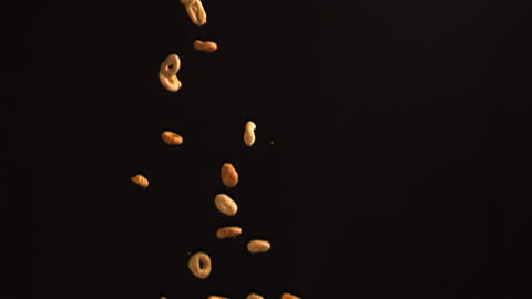 Cereal Hoops Falling Against Dark Background in Slow Motion