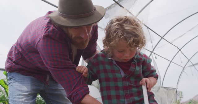 Father Teaching Young Son About Gardening in Greenhouse - Download Free Stock Images Pikwizard.com
