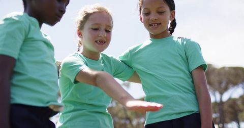 School-age girls bonding outdoors playing together during recess or sports day