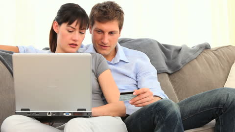 Couple Shopping Online on Laptop with Credit Card
