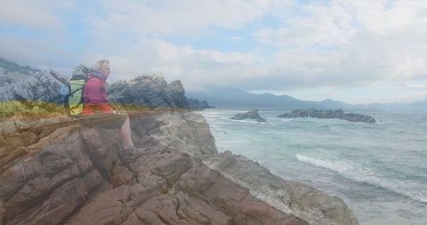 Senior Hiker Contemplating Waves by Rocky Coastal Bluff