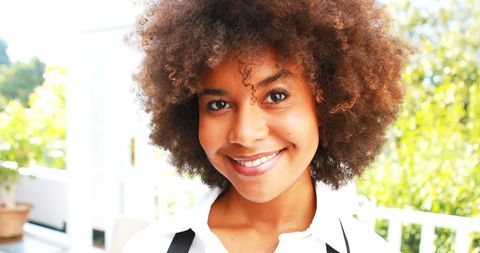 Smiling Waitress With Afro Hairstyle Serving in Sunlit Restaurant