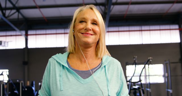 Smiling Senior Woman Wearing Hoodie Listening to Music at Gym - Download Free Stock Images Pikwizard.com