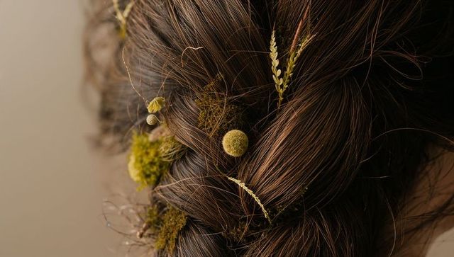 Braided brown hair featuring dried billy-buttons, moss and wheat macro styling