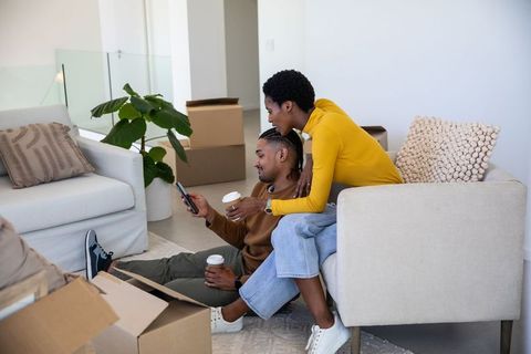 Couple Enjoying Coffee While Unpacking in New Home
